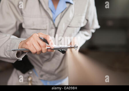 Carpenter measuring wood plank with vernier caliper in factory, Jiangsu, China Stock Photo