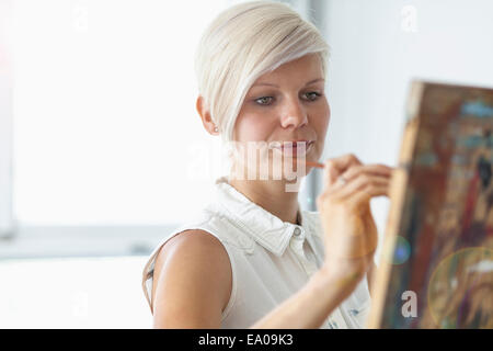 Female artist painting at easel Stock Photo