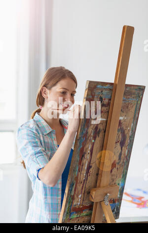 Female artist painting at easel Stock Photo