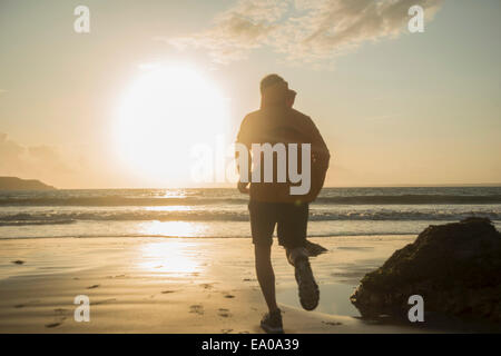 Mature man, running along beach Stock Photo