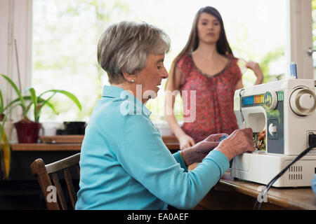Senior woman using sewing machine Stock Photo