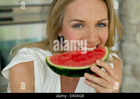 Mature woman biting watermelon