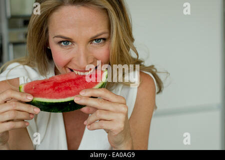 Mature woman biting watermelon