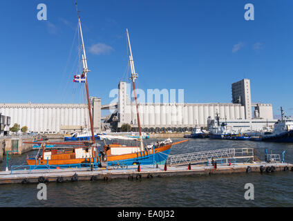 Old wooden sailing boat moored in front of the Bunge grain silos, Quebec City, Quebec, Canada Stock Photo