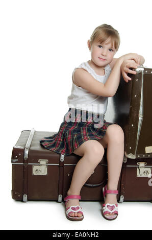 The little girl on old suitcases Stock Photo