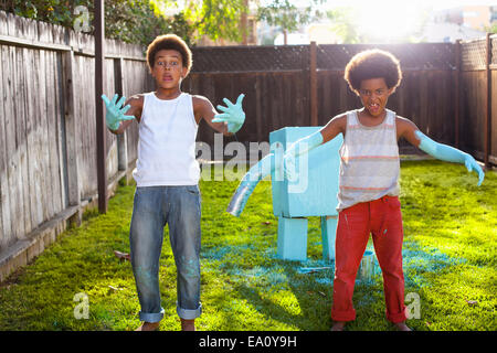 Portrait of two brothers in garden with light blue paint on hands and arms Stock Photo