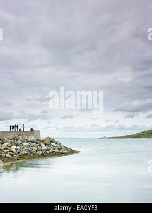 Group of people standing on harbor wall, Howth, Dublin Bay, Republic of Ireland Stock Photo