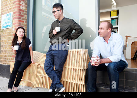 Three architect colleagues taking coffee break outside office Stock Photo
