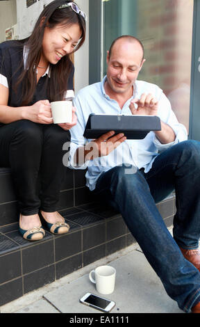 Two architect colleagues looking down at digital tablet on office step Stock Photo