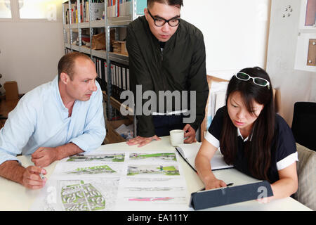 Team of three architects inspecting ideas for blueprint in office Stock Photo