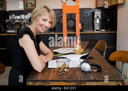 Mid adult woman in cafe with paperwork Stock Photo