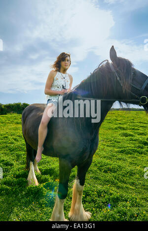 Portrait of young woman riding horse in field Stock Photo