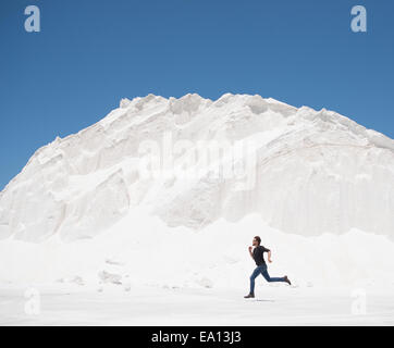 Man running in front of white mountain Stock Photo