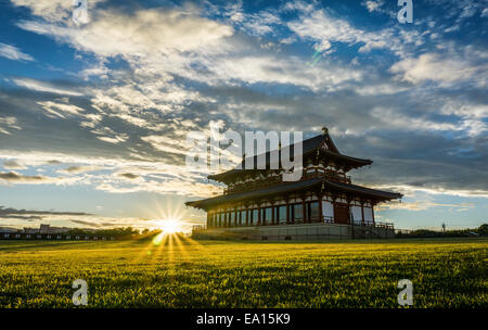 Large traditional Japanese royal palace building in a green field at sunset. Daigokuden audience hall at, Heijo Palace Site, in Nara, Japan Stock Photo