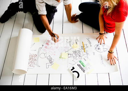 Graphic designers brainstorming on floor Stock Photo