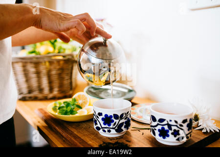 Woman preparing lemon and mint tea Stock Photo