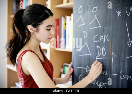 Woman writing on blackboard Stock Photo