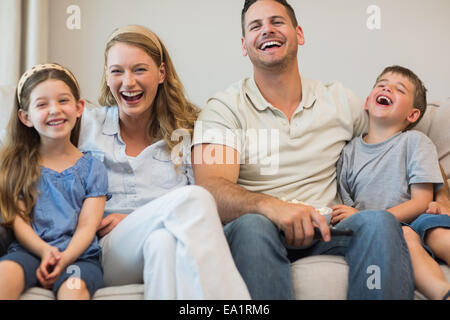 Happy family sitting on sofa Stock Photo