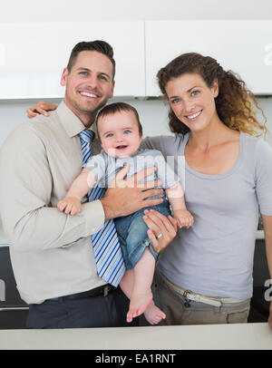 Happy parents with baby in kitchen Stock Photo