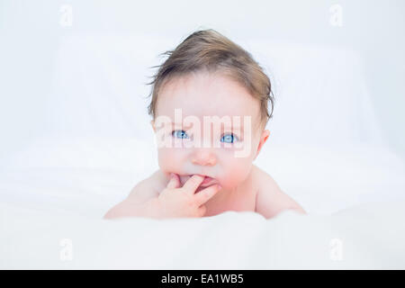 Cute baby with finger in mouth Stock Photo