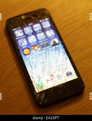 Apple iPhone 5 smartphone mobile phone with a cracked and broken glass display screen  Model Release: No.  Property release: No. Stock Photo