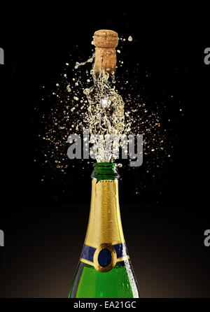 Celebration theme. Bottle of champagne with flying cork, isolated on black background Stock Photo