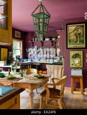 Swiss 1880's Walnut table in kitchen with Barrister chairs, large verdigris lantern and French crockery Stock Photo