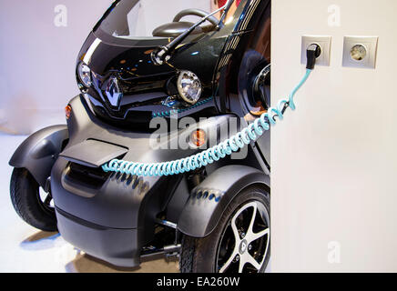 An electric car of the brand Renault Twizy is charged on the charging station. Stock Photo
