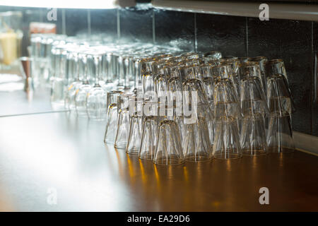 Various Empty Clean Beverage Glasses Piled in Upside Down on Wooden Table at the Bar Stock Photo