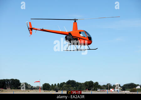 A small helicopter, used for flight training, taking off from an airport. Stock Photo