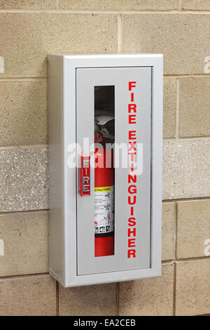 A fire extinguisher in a wall mounted storage box Stock Photo