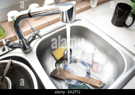 Kitchen conceptual image. Dirty sink with many dirty dishes. Stock Photo