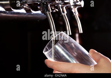 Alcohol conceptual image. Bartender giving the beer from dispenser. Stock Photo