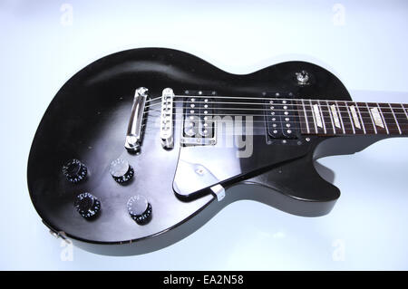 Music conceptual image. Black electric guitar on isolated background. Stock Photo