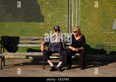 A couple sitting on Boardwalk, Brighton Beach, Brooklyn, New York, United States of America Stock Photo