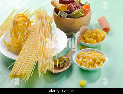 Different types of pasta on a wooden table Stock Photo