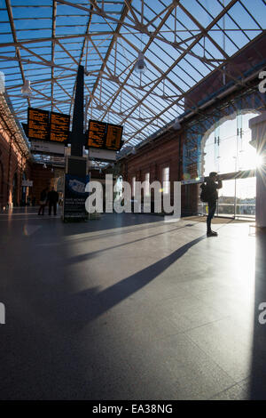 A photographer takes pictures in the shadows of the newly refurbished train station in Nottingham City, England UK Stock Photo