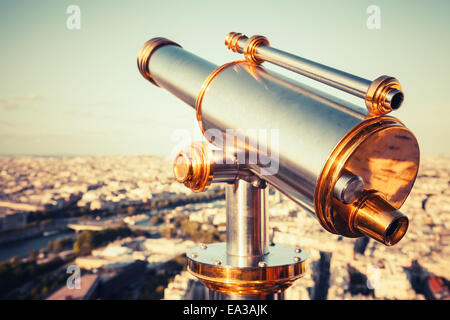 Shining metal telescope mounted on the railings of Eiffel Tower, Paris. Retro stylized vintage tonal correction filter effect Stock Photo