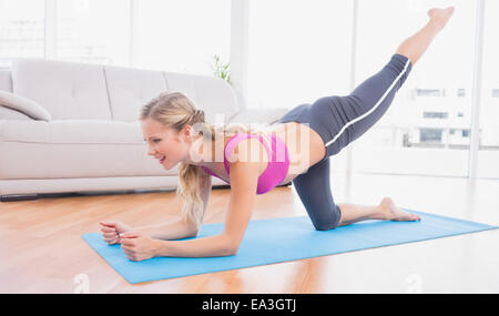 Toned blonde doing pilates on exercise mat Stock Photo