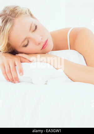 Pretty young blonde sleeping on her bed Stock Photo