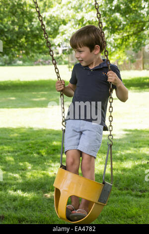 Young Boy Playing in Backyard Swing, USA Stock Photo