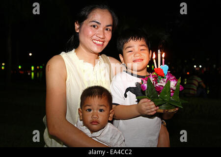 Chatuchak Park's lake, Bangkok, Thailand. 6th November 2014. A family pose with their krathong (small vessel) during Loi Krathong, an annual Thai festival during which people give thanks to the goddess of water (Phra Mae Khongkha) and seek forgiveness for past misdeeds. Credit:  Maria J Atkins/Alamy Live News Stock Photo