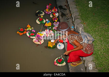 Chatuchak Park's lake, Bangkok, Thailand. 6th November 2014. A woman places her krathong (small vessel) in the water during Loi Krathong, an annual Thai festival during which people give thanks to the goddess of water (Phra Mae Khongkha) and seek forgiveness for past misdeeds. Credit:  Maria J Atkins/Alamy Live News Stock Photo