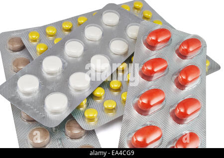 Red, yellow, white and brown pills in blister packs close-up isolated in white Stock Photo