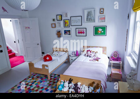 Soft toys on single bed in girls room of London home, UK. Stock Photo