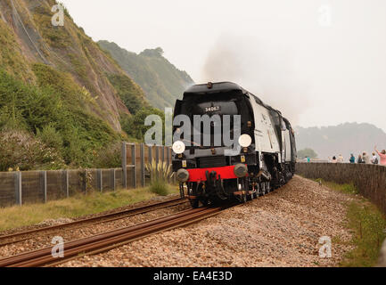Battle of Britain class pacific No 34067 Tangmere travelling alongside the sea wall with the Royal Duchy steam excursion. 7th September 2014. Stock Photo