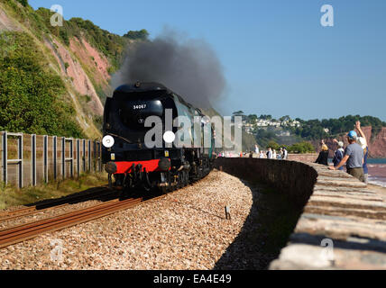 Battle of Britain class pacific No 34067 Tangmere travelling alongside the sea wall with the Royal Duchy steam excursion. 21st September 2014. Stock Photo