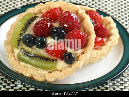 two mixed fruit tarts on a small plate Stock Photo
