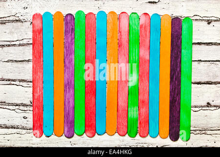 Colorful lollipop sticks on a wooden surface as a background Stock Photo