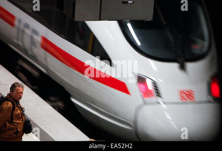 Berlin, Germany. 6th Nov, 2014. A man stands and watches as a train leaves a platform of the central train station in Berlin, Germany, on Nov. 6, 2014. German train drivers staged a record-long strike against state-owned railway company Deutsche Bahn (DB) on Wednesday, ignoring criticism and appeals from passengers, business and government. The strike began with DB's freight train drivers laying down their jobs as planned on Wednesday afternoon and involved passenger train drivers from early Thursday. © Zhang Fan/Xinhua/Alamy Live News Stock Photo